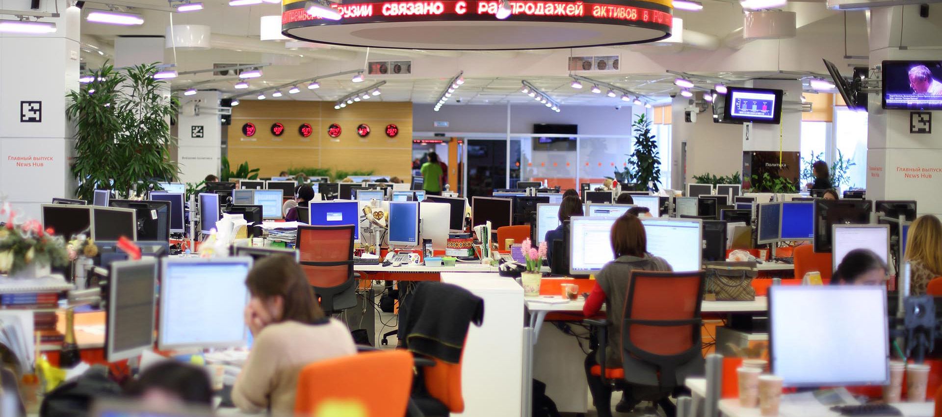 An open-plan office full of desks and screens